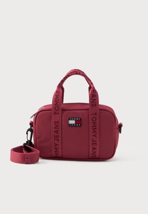 Geanta dreptunghiulară mică de culoare maronie Tommy Jeans, cu închidere cu fermoar, două mânere superioare, curea de umăr detașabilă și patch cu logo pe față.