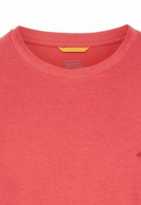 Rød T-shirt lavet af blød bomuld, med rund hals, korte ærmer og en lille logo-detalje. Glat tekstur med et minimalistisk design.