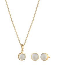 Goldfarbener Schmuckset bestehend aus einer Halskette mit runder, klarer Steinanhänger und passenden runden Ohrsteckern, alle mit glatten, polierten Oberflächen.