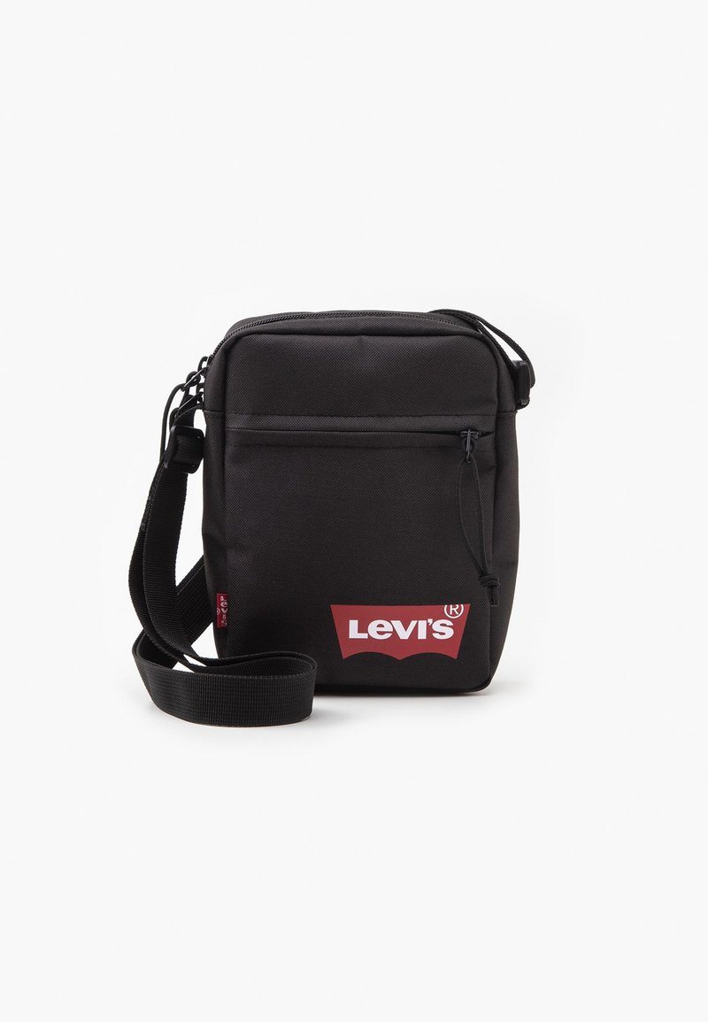 Bolso bandolera negro hecho de tela duradera, con un bolsillo frontal con cremallera y un logotipo rojo de Levi's. Incluye una correa ajustable.