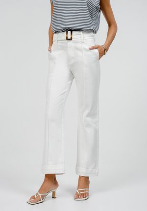 White high-waisted trousers with front pockets and side seams, featuring a wide-leg fit and rolled cuffs. Paired with a gray striped top and white sandals.