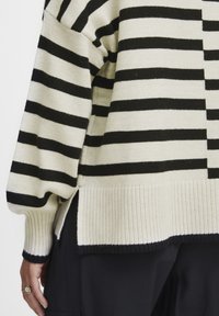Schwarz-cream gestreifter Pullover aus gestricktem Stoff. Verfügt über eine weit geschnittene Silhouette, gerippte Bündchen, seitliche Schlitze und einen strukturierten Saum.