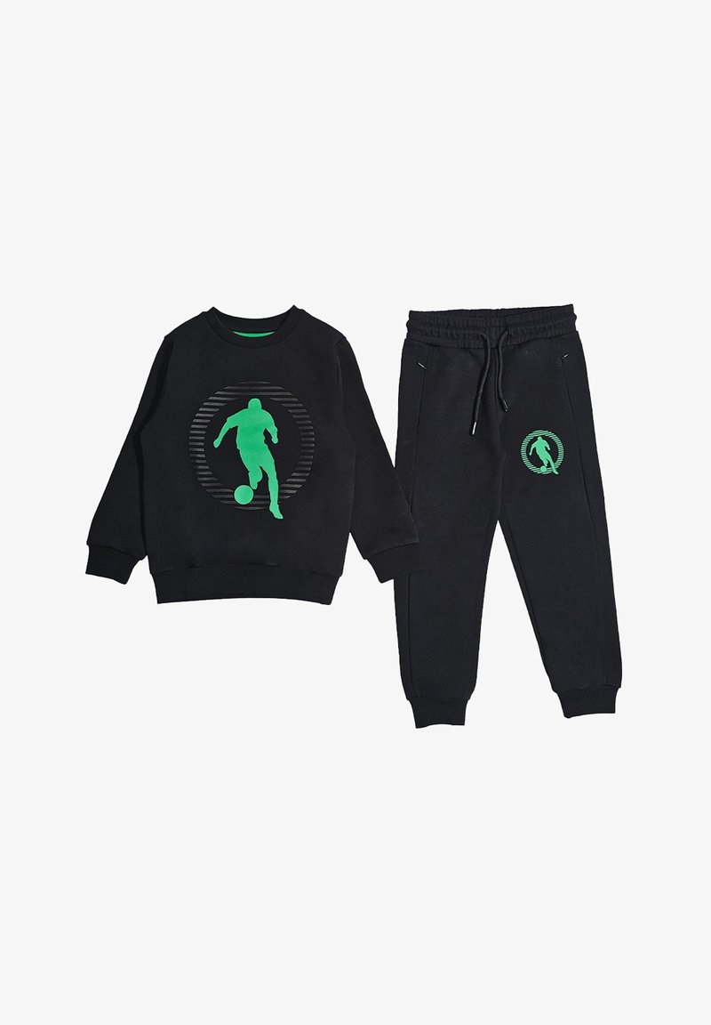 Set di felpa nera e pantaloni tuta neri con la silhouette verde di un calciatore e di un pallone all'interno di un design circolare a strisce su entrambi i capi.