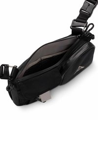 Sacoche noire à porter en bandoulière avec sangle ajustable, compartiment principal partiellement ouvert montrant une poche en mesh intérieure, et poche avant zippée avec patch logo.
