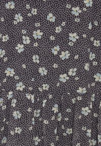 Tecido floral com um fundo azul-marinho escuro, apresentando pequenas flores azuis claras e brancas. A textura parece leve, com caimentos suaves.