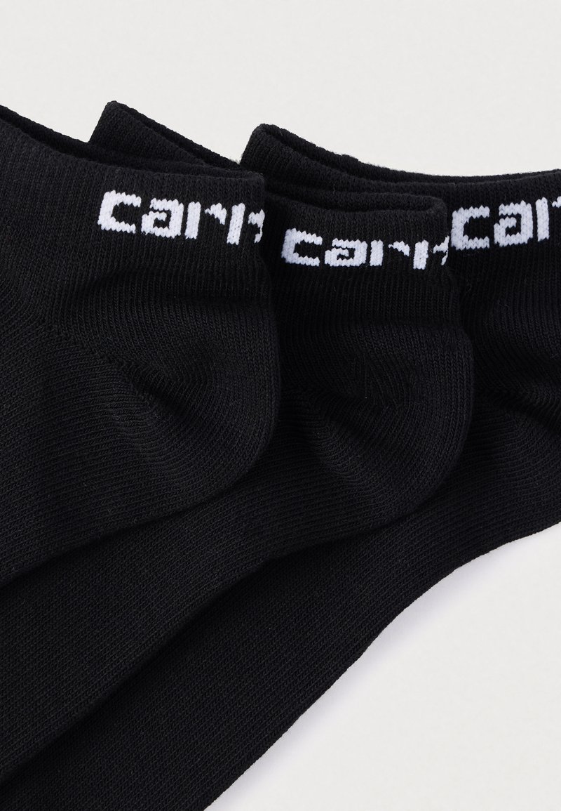 Drei Paar schwarze Socken mit geripptem Muster, versehen mit weißer "cari"-Markierung am Bund, für Knöchelschutz entworfen.