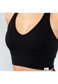 Zwarte geribde crop top met een V-hals ontwerp, voorzien van een aansluitende pasvorm en een klein wit logo label aan de onderkant links.