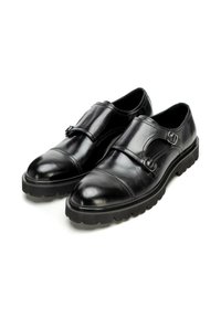 Schwarze Lederschuhe mit runder Spitze, ausgestattet mit zwei Schnallen und einer strukturierten Gummisohle für zusätzlichen Halt und Haltbarkeit.
