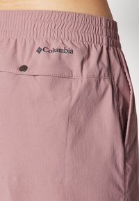 Ljusrosa Columbia-shorts med elastisk midja, en bakficka och synliga sömdetaljer. Mjuk, lättviktsväv.