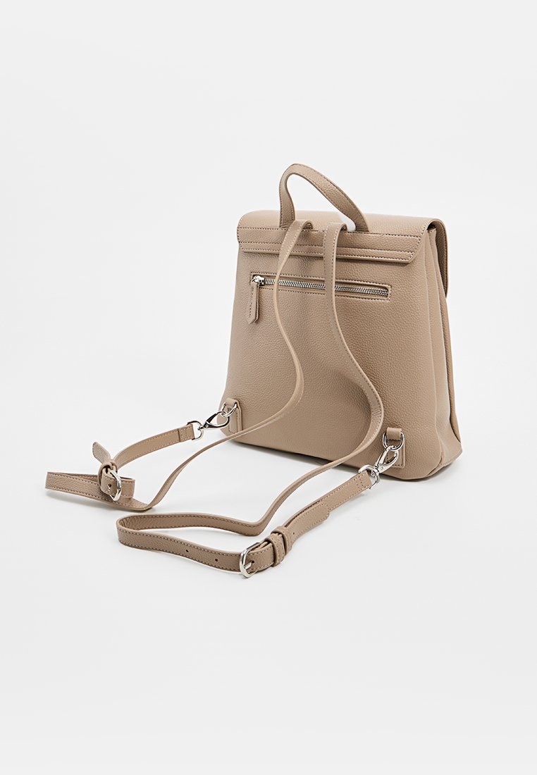 Zaino in pelle beige con una forma strutturata, manico superiore, spallacci regolabili e una tasca frontale con zip. Texture liscia e design minimalista.