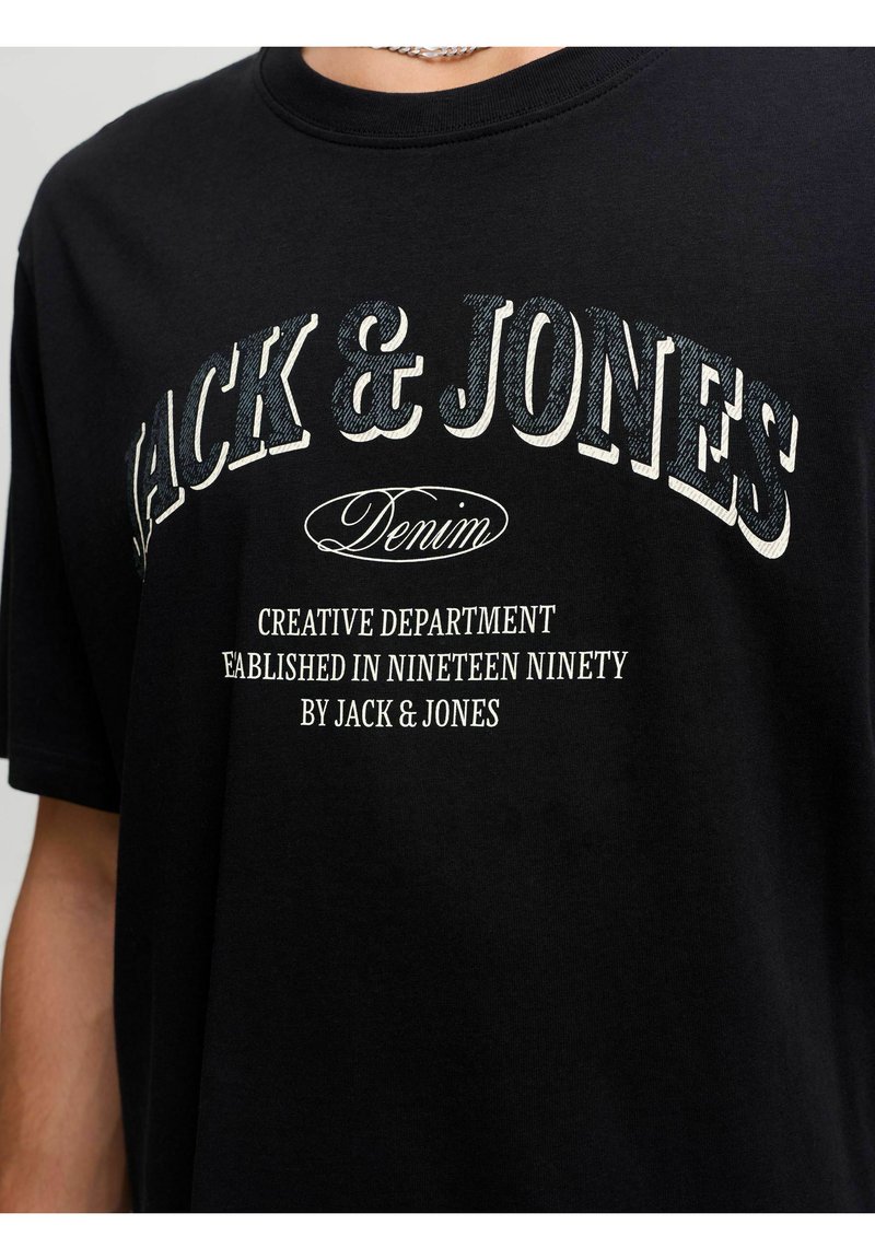 Μαύρο T-shirt με μεγάλο λευκό κείμενο "JACK & JONES Denim" και μικρότερο κείμενο "Creative Department Established in Nineteen Ninety by Jack & Jones."