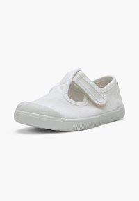 Chaussure en toile blanche pour enfants avec semelle en caoutchouc et bride velcro réglable sur fond blanc uni.