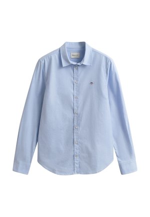 Svetlomodrá košeľa s dlhým rukávom vyrobená z bavlny. Má zapínanie na gombíky pri golieri, gombíky vpredu a malú nášivku na hrudi. Hladká textúra.