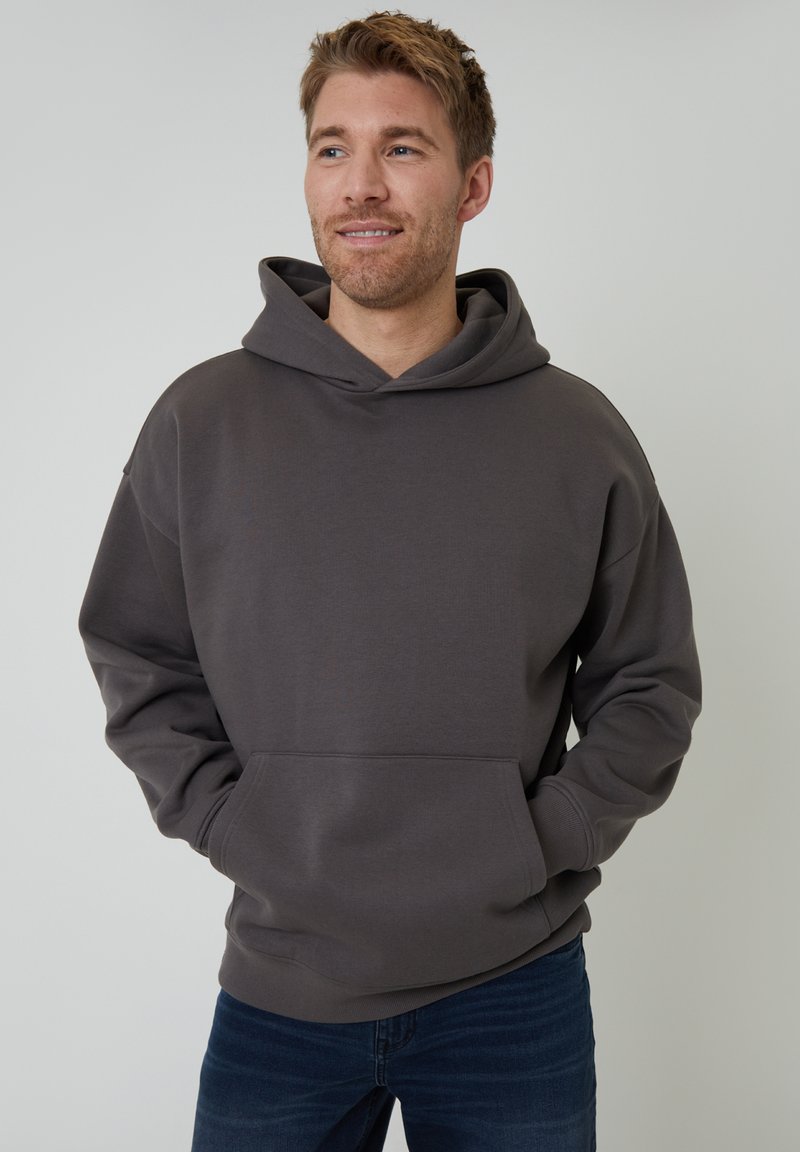 Mørkegrå hættetrøje lavet af blødt, tykt stof med en frontlomme og justerbar snøre. Afslappet pasform med ribbede manchetter og kant.