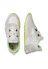 Sneaker bianchi e beige con finitura testurizzata, dettagli in verde neon, accessori neri e linguetta imbottita con branding.