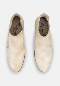 Jasnobeżowe buty slip-on z miękkiej skóry. Charakteryzują się gładką fakturą i minimalnymi przeszyciami, okrągłym noskiem oraz płaską podeszwą.