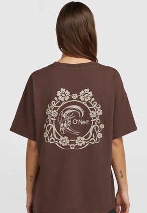 Persoon met lang bruin haar draagt een bruin t-shirt met een beige bloemmotief in een cirkel en het O'Neill-logo op de rug.
