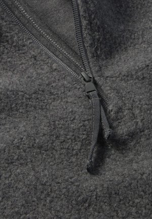 Grijze fleece stof met een gladde textuur, voorzien van een zwarte rits sluiting en een treklipje, die praktische ontwerpelementen benadrukt.