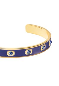 Bracelet à manche en ton doré avec une bande d'émail bleu profond, présentant des accents hexagonaux alternés et des pierres bleu clair intégrées.