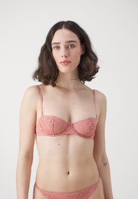 Nertinis rožinis liemenėlė su lankeliu ir reguliuojamomis petnešėlėmis; visame paviršiuje gėlių raštas; atitinkantis nėrinių bikini dugnas; minkštas audinys.