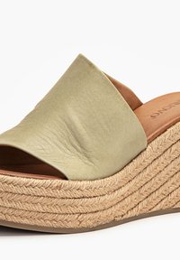 Sandale compensée en cuir beige avec bout ouvert et semelle plateforme en jute tressé.