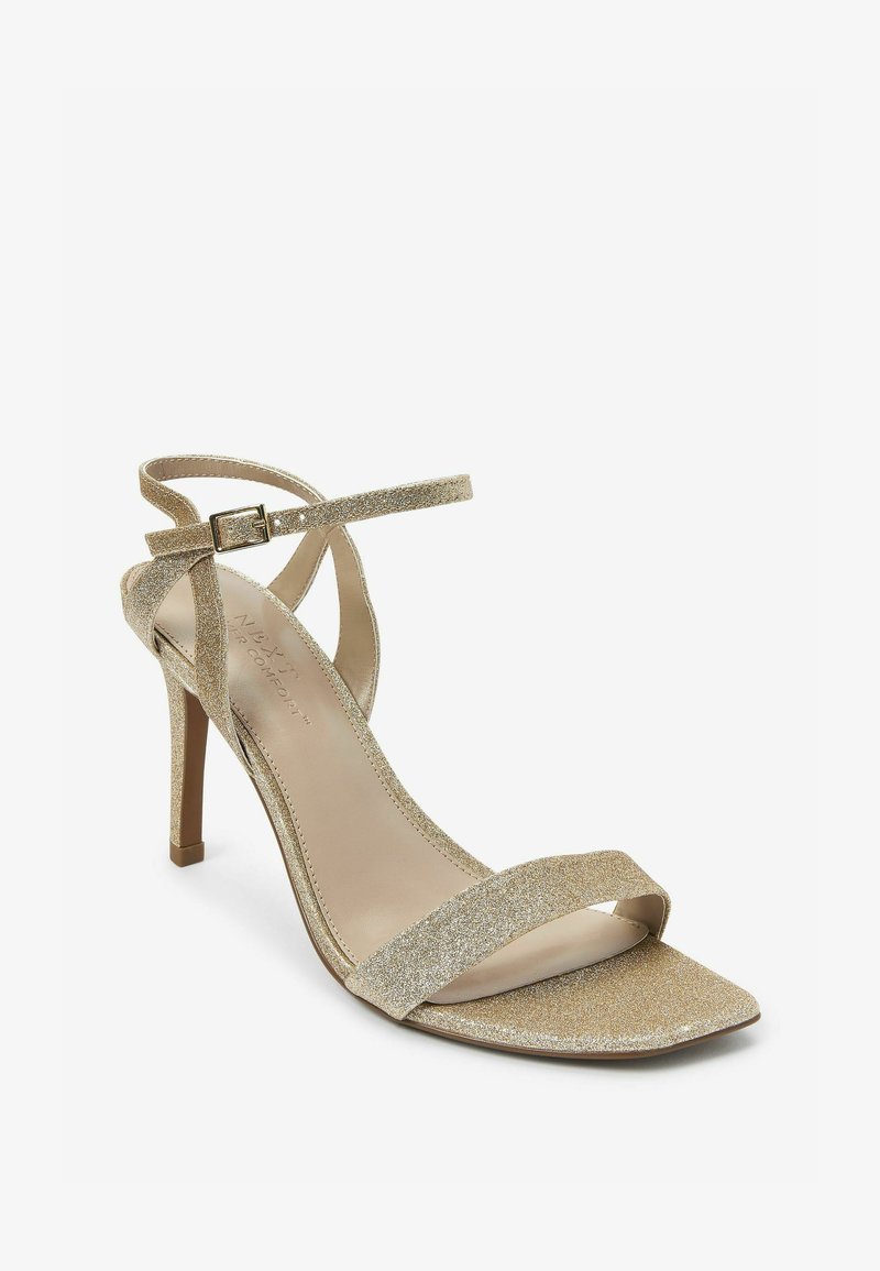 Gyldne glimmer hæle sandals med åben tå-design, tynde stropper og en spændeankelrem; høj stilettohæl; glat indersål.