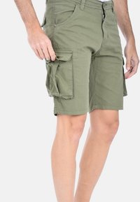 Pantaloni cargo verdi in cotone, dotati di numerose grandi tasche laterali, zip frontale e una vestibilità casual.