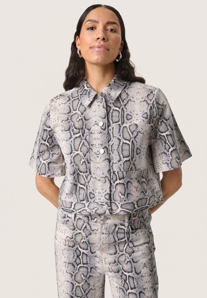 Chemise à manches courtes cintrée et pantalon assorti en motif serpent gris et noir, avec des boutons et un col pointu. Texture lisse.
