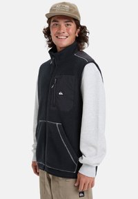Black fleece vest with gray sleeves, featuring a zippered chest pocket, contrasting stitching, and an embroidered logo on the pocket.