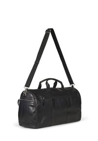 Bolsa de viaje de cuero negro con un bolsillo frontal con cremallera, asas superiores y una correa ajustable. Presenta una textura suave y un diseño estructurado.
