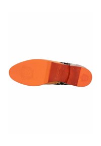 Chaussure à imprimé léopard vue par le dessous, avec un dessus noir texturé, une semelle plate orange et un détail de logo embossé sur le talon.