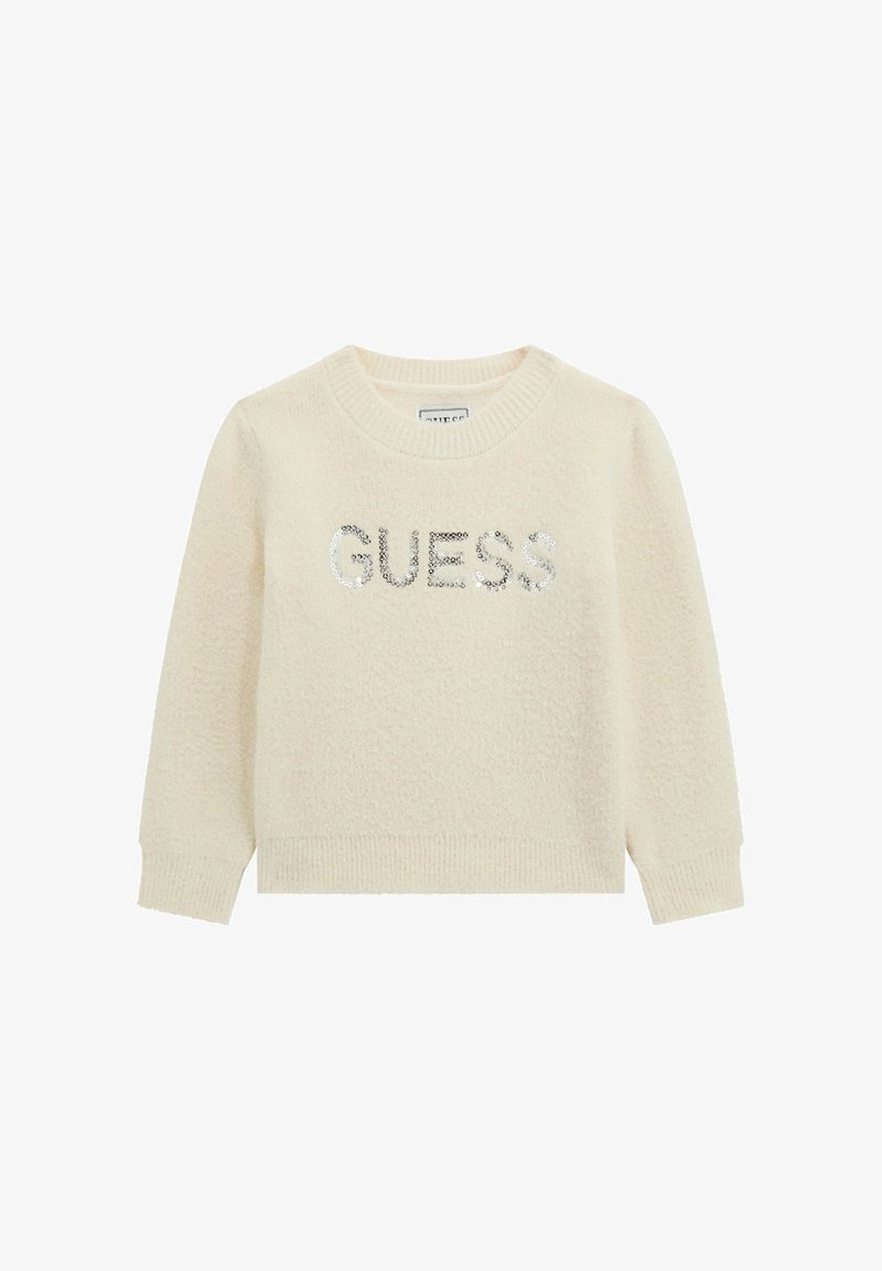 Pull à manches longues couleur crème avec poignets et ourlet côtelés, avec le mot "GUESS" en sequins argentés sur la poitrine.