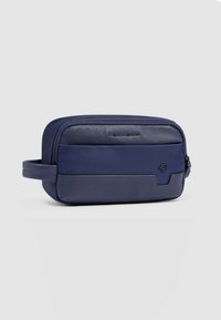 Marineblauwe toilettas met gemengde texturen, voorzien van een ritssluiting, zijhandvat en een geperst logo op het voorpaneel.