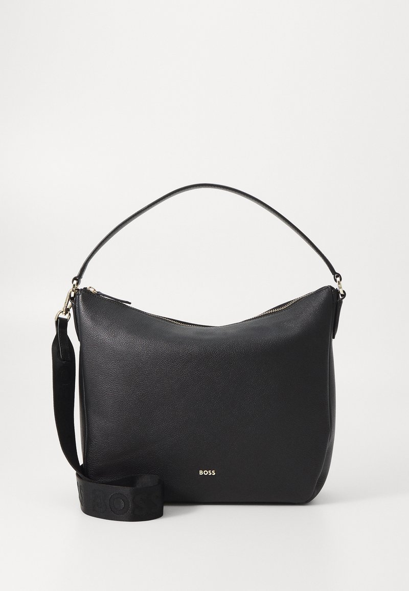 Borsa a tracolla in pelle nera con una forma curvata, chiusura a zip e tracolla removibile con marchio in rilievo. Texture liscia, design minimalista.