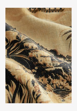 Lätt tyg med en beige bakgrund och ett svart botaniskt mönster samt detaljerade landskapselement, inklusive hus och växtlighet.