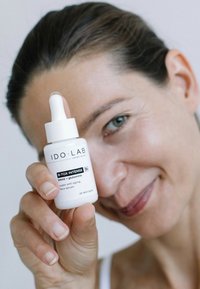 Serum do twarzy IDOLAB B-TOX INTENSE w białej butelce z pipetą, z czarnymi etykietami. Gładkie wykończenie, kompaktowy design.