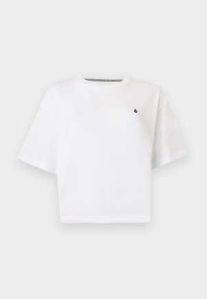 Tricou alb scurt cu mâneci scurte, cropat, cu un mic logo negru pe partea stângă a pieptului, cu guler rotund și croială lejeră, pe un fundal simplu.