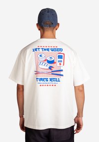 Hvid bomulds t-shirt med et farverigt grafisk print på ryggen med sushi-illustrationer, tekst i blå og rød, samt en afslappet pasform.