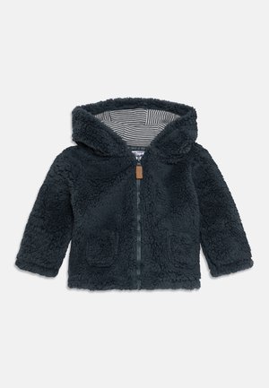 Veste enfant bleu marine foncé en tissu duveteux avec capuche, fermeture éclair à l'avant, deux poches avant et doublure rayée à l'intérieur de la capuche.
