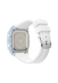 Montre avec un bracelet en silicone blanc, un boîtier en résine transparent, un dos en acier inoxydable et des éléments en argent. Elle présente un cadran rond et des boutons texturés.