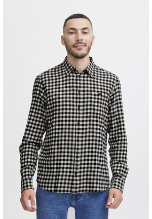 Button-up shirt in black and beige check pattern. Long sleeves, single chest pocket, and standard collar. Fabric appears textured.