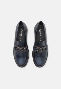 Paire de mocassins noirs en cuir à enfiler avec un détail de chaîne dorée épaisse, marqué Gabor comfort, taille 4½, vue de dessus.