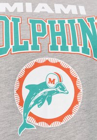 Šedé tričko s potiskem "Miami Dolphins" v tyrkysové a oranžové barvě. Grafika delfína se přilbou, obklopená oranžovými a bílými designovými akcenty v kruhovém tvaru.