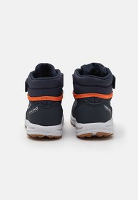 Dark blue mid-top shoes with orange accents, Velcro straps, textured fabric, and a white rubber sole with a gum-colored grip.