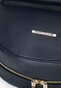 Borsa in pelle nera testurizzata con cerniera e accessori in oro. Presenta una placca con il logo oro con il nome "Wittchen" sul davanti.
