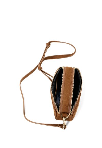 Bruine suède crossbodytas met twee ritsvakken en verstelbare riem, open weergegeven tegen een witte achtergrond.