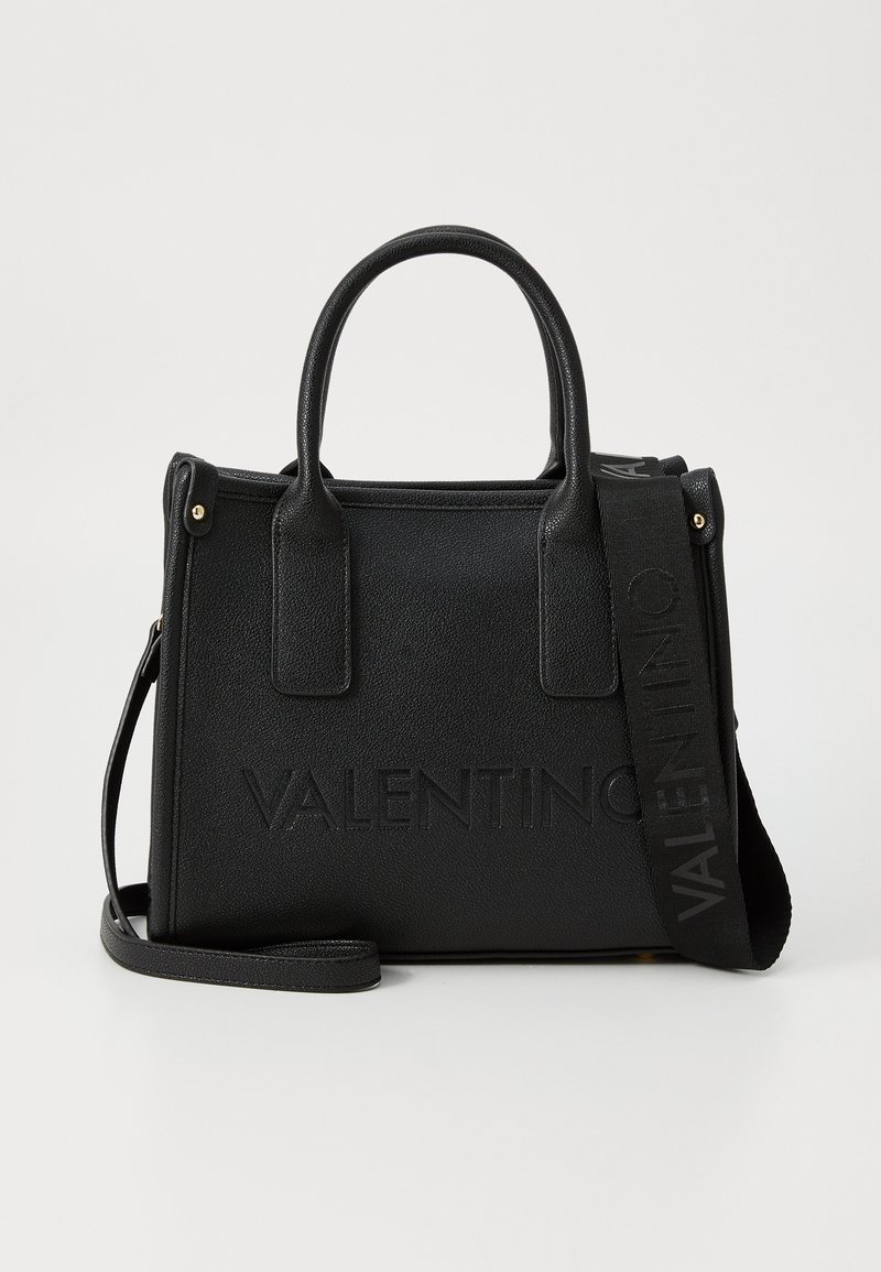 Black textured handbag with dual top handles, detachable shoulder strap, embossed branding, and gold-tone hardware accents.