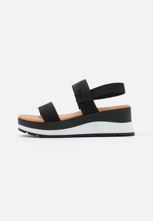 Black sandals with two wide straps and a supportive back strap. Features a chunky white midsole and textured black upper material.