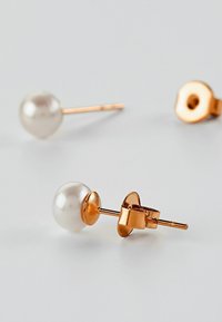 Orecchini a perno color oro con perle bianche rotonde e lucide, dotate di una superficie liscia e di un semplice retro sicuro.