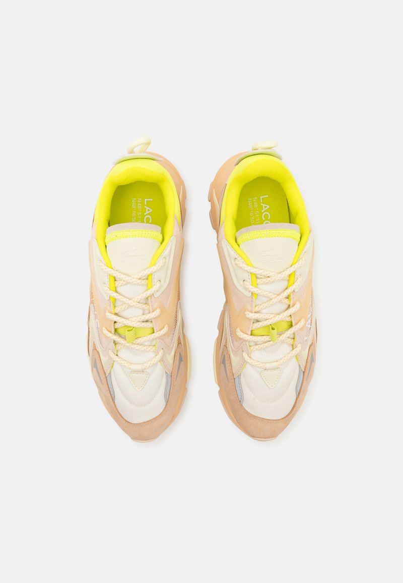 Multimateriaal sneakers met een lichtbeige bovenwerk, gele accenten en getextureerde overlays. Dikke zool met een opvallend vetersysteem.